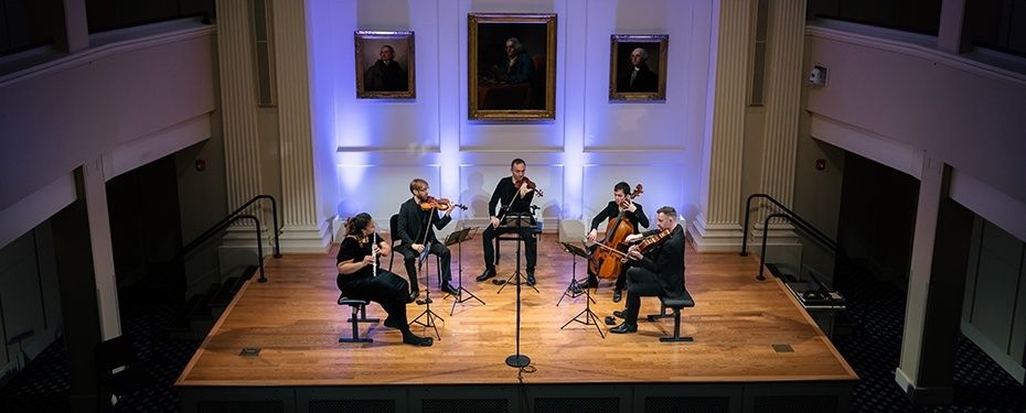Quintette à cordes interprétant un concert intime sur une scène éclairée